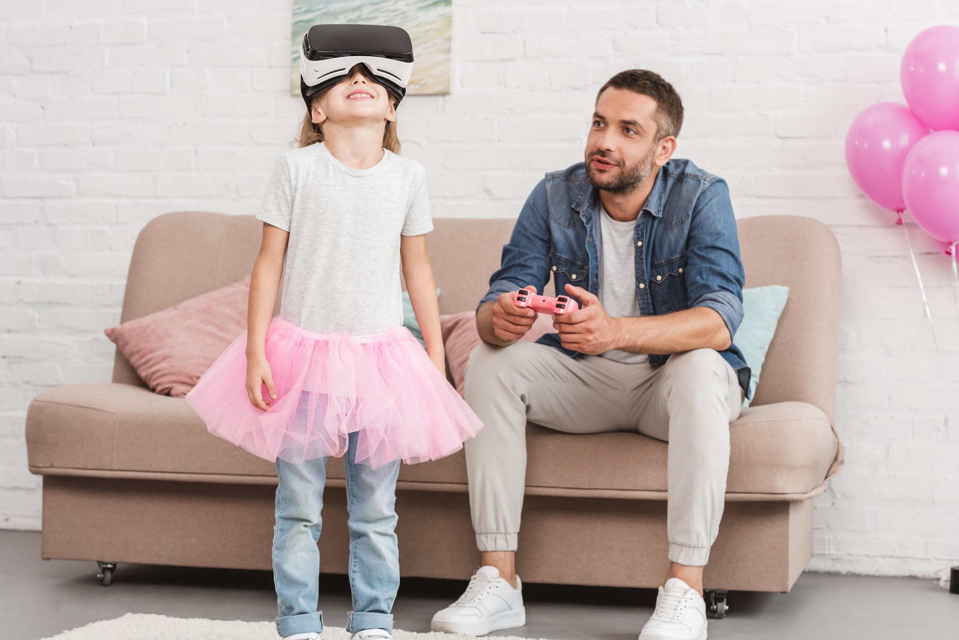 father and daughter using virtual reality headset and joystick at home